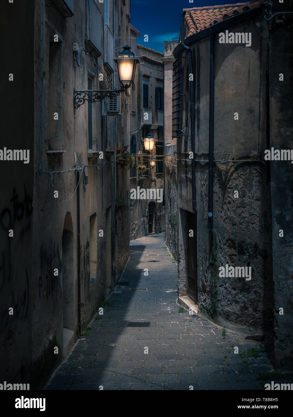 Rues de tropea en Italie en sombre nuit ou en soirée. Lampes lanternes lumineuses éclairées l'ancienne buildnings et voies étroites. Banque D'Images