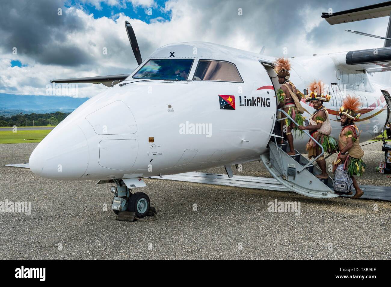 La Papouasie-Nouvelle-Guinée, province, Hela, tribu Huli zone, Kobe Tumbiali Tari village, danseurs prêt pour un sing-Sing (fête traditionnelle) l'embarquement dans un avion d'Air Niugini Banque D'Images