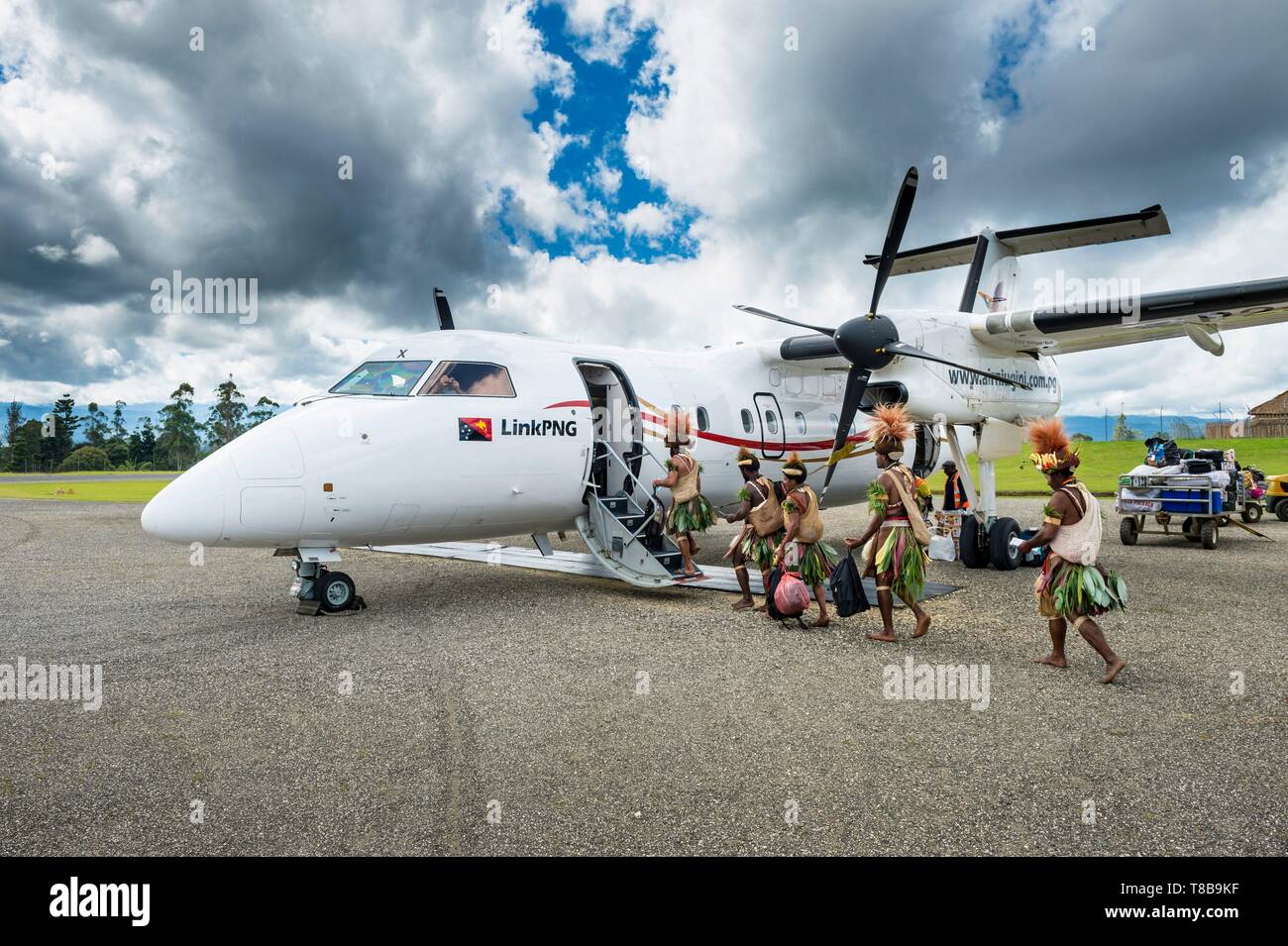 La Papouasie-Nouvelle-Guinée, province, Hela, tribu Huli zone, Kobe Tumbiali Tari village, danseurs prêt pour un sing-Sing (fête traditionnelle) l'embarquement dans un avion d'Air Niugini Banque D'Images