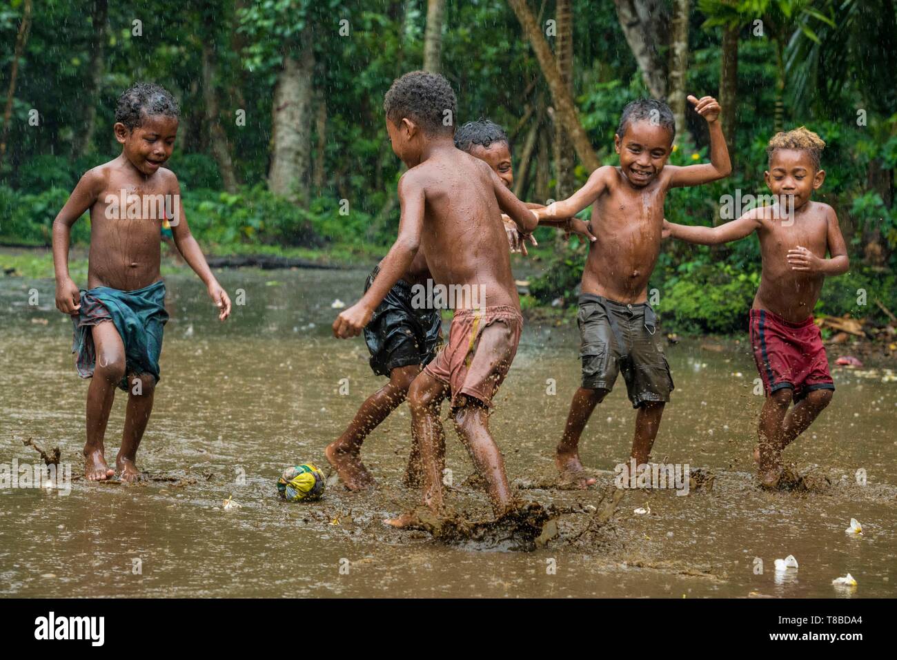 La Papouasie-Nouvelle-Guinée, Milne Bay Province, Encastreaux Trobriands, la mer, l'archipel de l'île de Kiriwina, Okaiboma Village, enfants jouant au football Banque D'Images