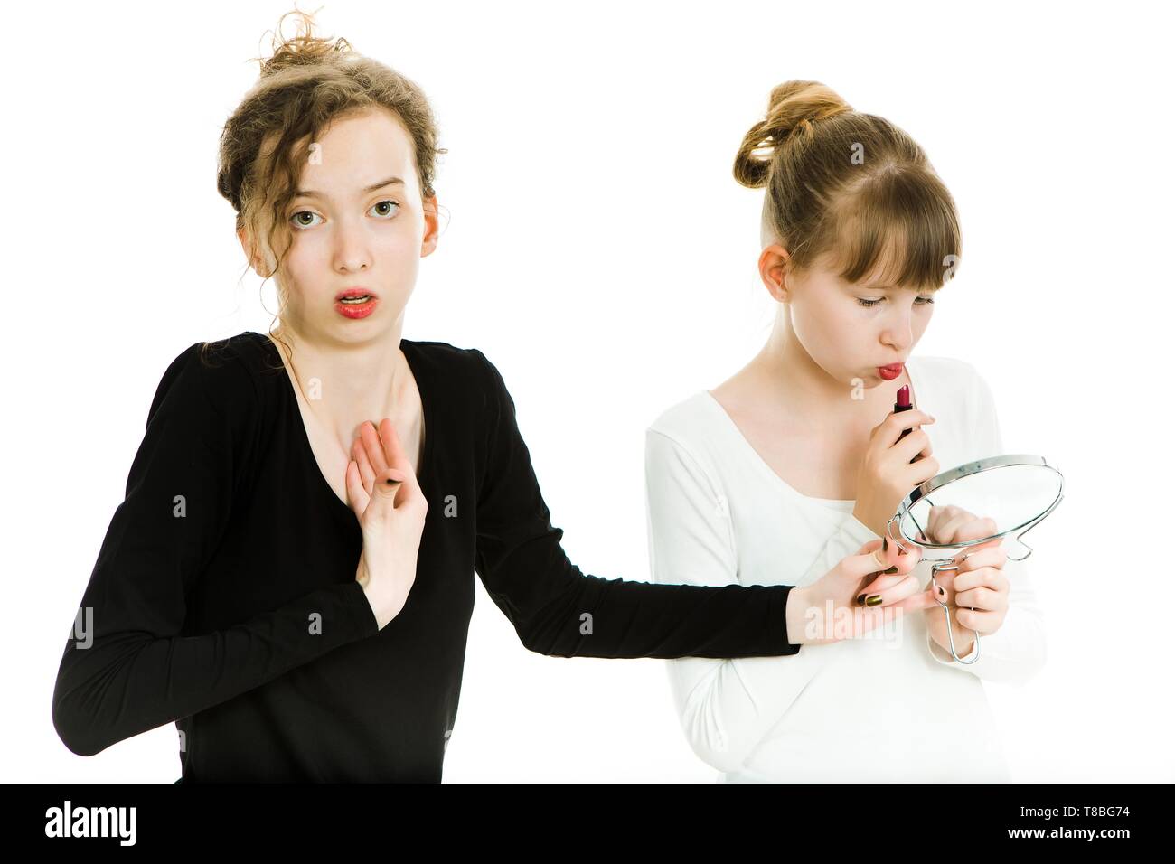 Deux adolescentes marchander pour obtenir un miroir pour faire un maquillage - rivalité soeur - Fond blanc Banque D'Images