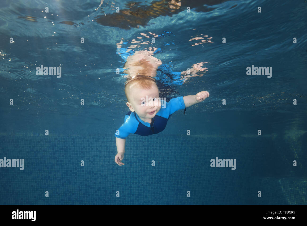 Petit Bebe Garcon Dans Une Combinaison Bleu Apprend A Nager Sous L Eau Dans La Piscine Vie Familiale Saine Et L Activite Des Enfants Sports D Eau Enfant Photo Stock Alamy