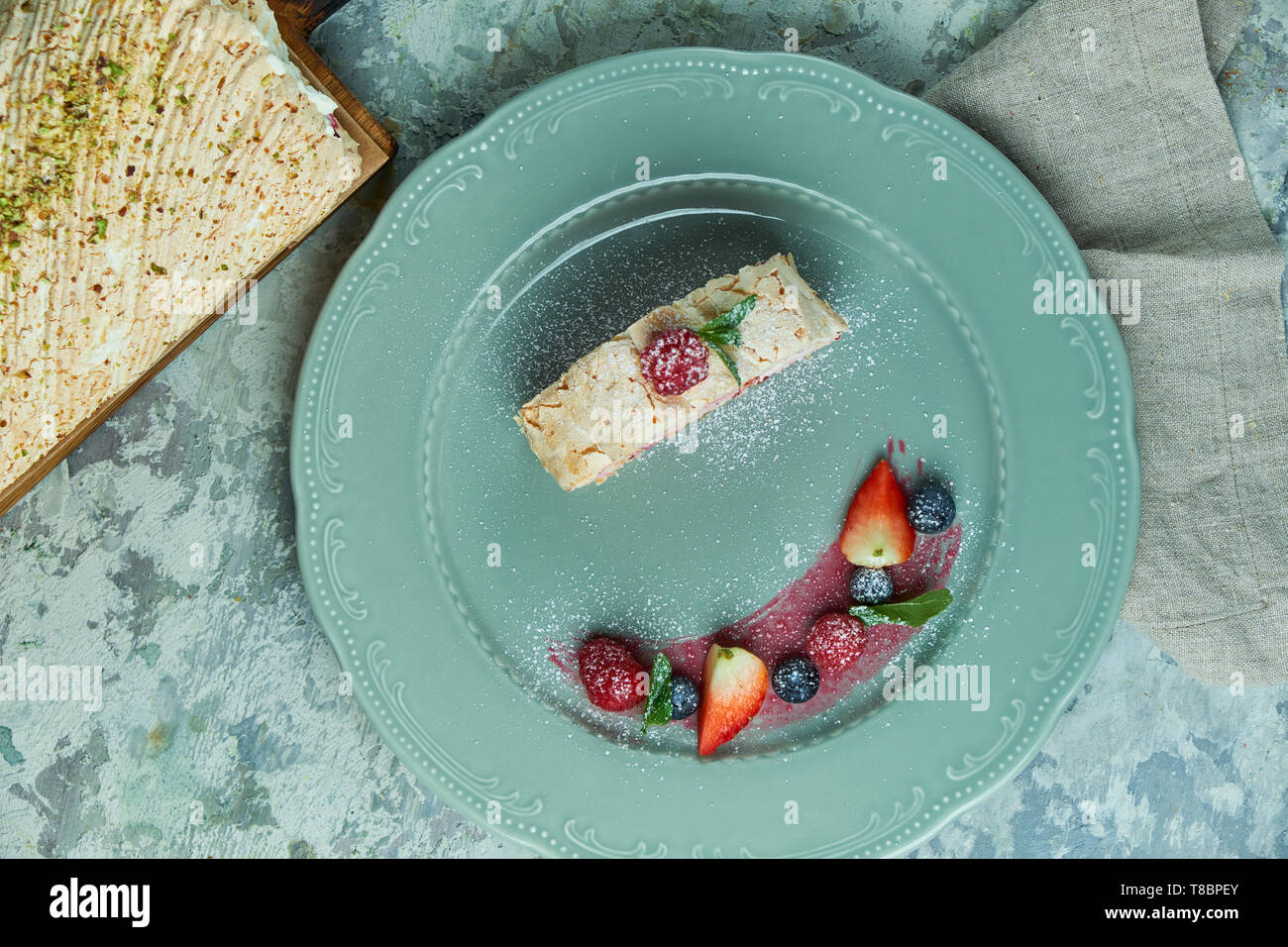 Gâteau roulé à la meringue tranche sur une assiette de fruits rouges Banque D'Images
