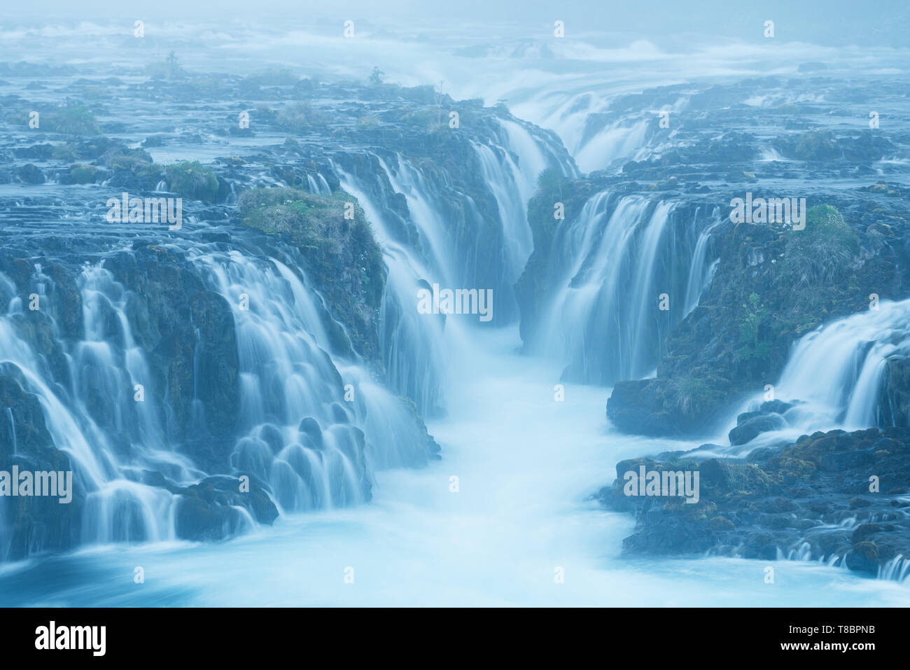 Bruarfoss cascade. L'eau est de couleur turquoise et de belles cascades. Attraction touristique de l'Islande. Le brouillard du matin Banque D'Images