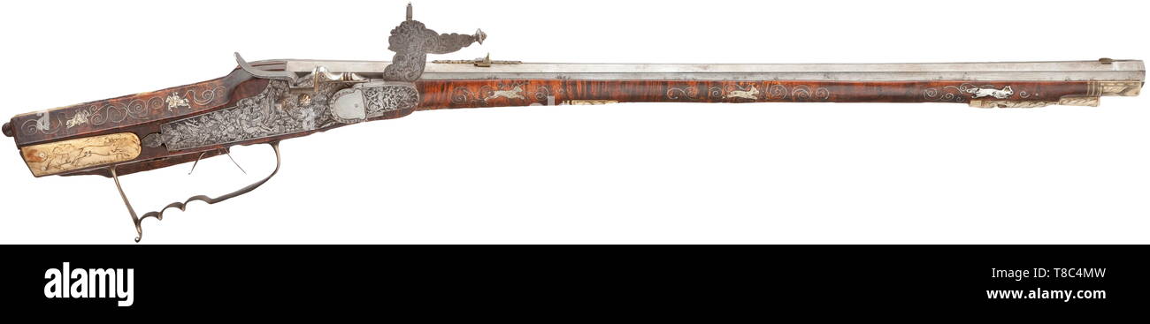 Un wheellock avec fusil allemand, fin du 17e siècle un peu débordé canon octogonal avec dix-groove canon rayé de calibre 14 mm, avec guidon en laiton d'aronde et pliage double avec vue arrière ajouré floral. Finement ciselés avec extrêmement wheellock captifs entre les trophées, des monstres, un Triton et de somptueuses décorations de la vrille. Couvrir avec gravures florales sur l'intérieur et de pignons. Double détente. Stock sculptés faits à partir de grains fins bois racine de thuya avec de l'os ainsi que des fils d'argent en forme de vrille entre incrustations hors, Additional-Rights Clearance-Info-Not-Available- Banque D'Images
