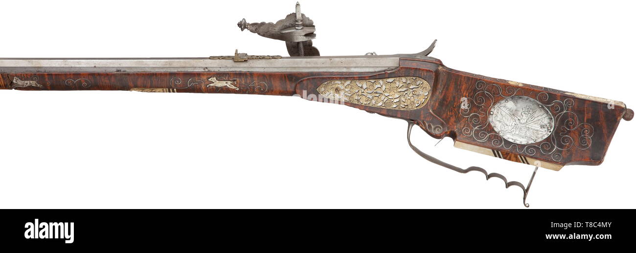 Un wheellock avec fusil allemand, fin du 17e siècle un peu débordé canon octogonal avec dix-groove canon rayé de calibre 14 mm, avec guidon en laiton d'aronde et pliage double avec vue arrière ajouré floral. Finement ciselés avec extrêmement wheellock captifs entre les trophées, des monstres, un Triton et de somptueuses décorations de la vrille. Couvrir avec gravures florales sur l'intérieur et de pignons. Double détente. Stock sculptés faits à partir de grains fins bois racine de thuya avec de l'os ainsi que des fils d'argent en forme de vrille entre incrustations hors, Additional-Rights Clearance-Info-Not-Available- Banque D'Images