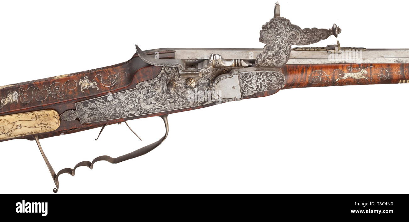 Un wheellock avec fusil allemand, fin du 17e siècle un peu débordé canon octogonal avec dix-groove canon rayé de calibre 14 mm, avec guidon en laiton d'aronde et pliage double avec vue arrière ajouré floral. Finement ciselés avec extrêmement wheellock captifs entre les trophées, des monstres, un Triton et de somptueuses décorations de la vrille. Couvrir avec gravures florales sur l'intérieur et de pignons. Double détente. Stock sculptés faits à partir de grains fins bois racine de thuya avec de l'os ainsi que des fils d'argent en forme de vrille entre incrustations hors, Additional-Rights Clearance-Info-Not-Available- Banque D'Images