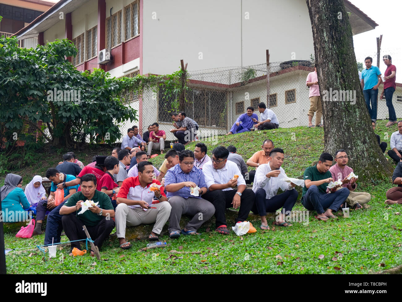 Les personnes mangeant le déjeuner dans un parc public, Kuala Lumpur, Malaisie Banque D'Images