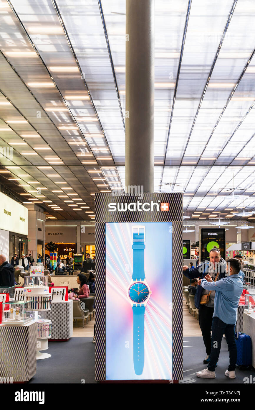 L'aéroport Charles De Gaulle, Paris, France. Intérieur du Terminal 2E salle  de départ. Swatch store avec grand écran éclairé stand et clients Photo  Stock - Alamy