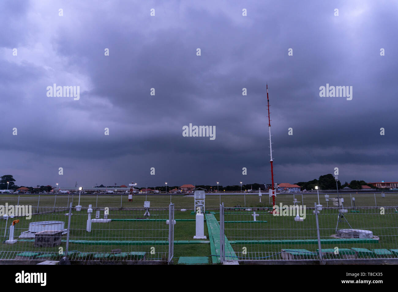 BALI-DEC 07 2017: Jardin météorologique à l'aéroport de Ngurah Rai Bali quand le ciel plein de nuages noirs cumulonimbus et cumulus et la pluie se produisent de loin Banque D'Images