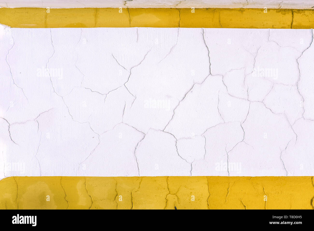 Des fissures sur le mur. Mur Blanc avec un contour jaune. Roulant le plâtre. Vieux millésime mur. Les lignes jaunes et blanches Banque D'Images