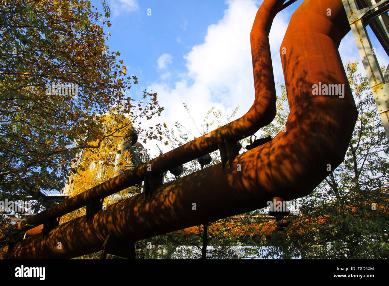 Landschaftspark Duisburg, Allemagne : isolées sur des pipelines n'est pas oxydée courbé contre le ciel bleu et arbres Banque D'Images