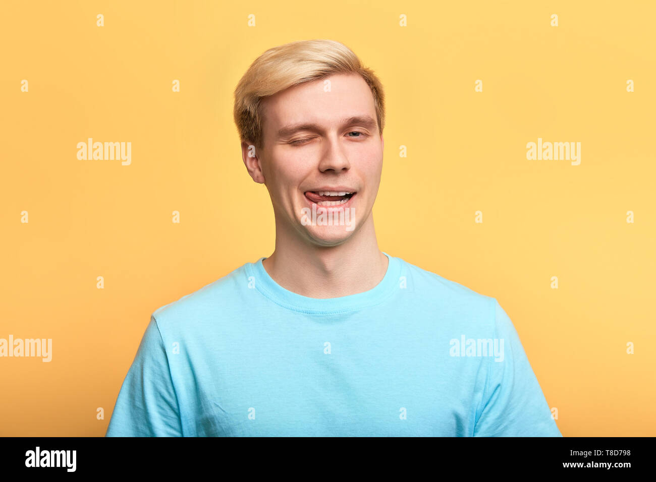 Dans l'homme fou et son bleu T-shirt faisant des grimaces en regardant la caméra, portrait, imiter, grimace concepts Banque D'Images