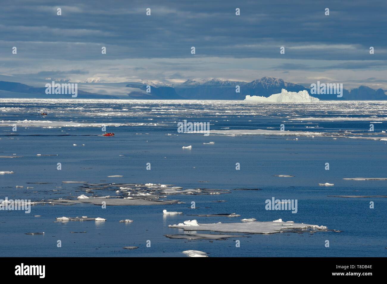 Le Groenland, côte nord-ouest, le détroit de Smith au nord de la baie de Baffin, morceaux de glace de la mer arctique et une exploration du zodiaque MS Fram cruche de navire Hurtigruten iceberg géant à l'arrière-plan vers la Banque D'Images