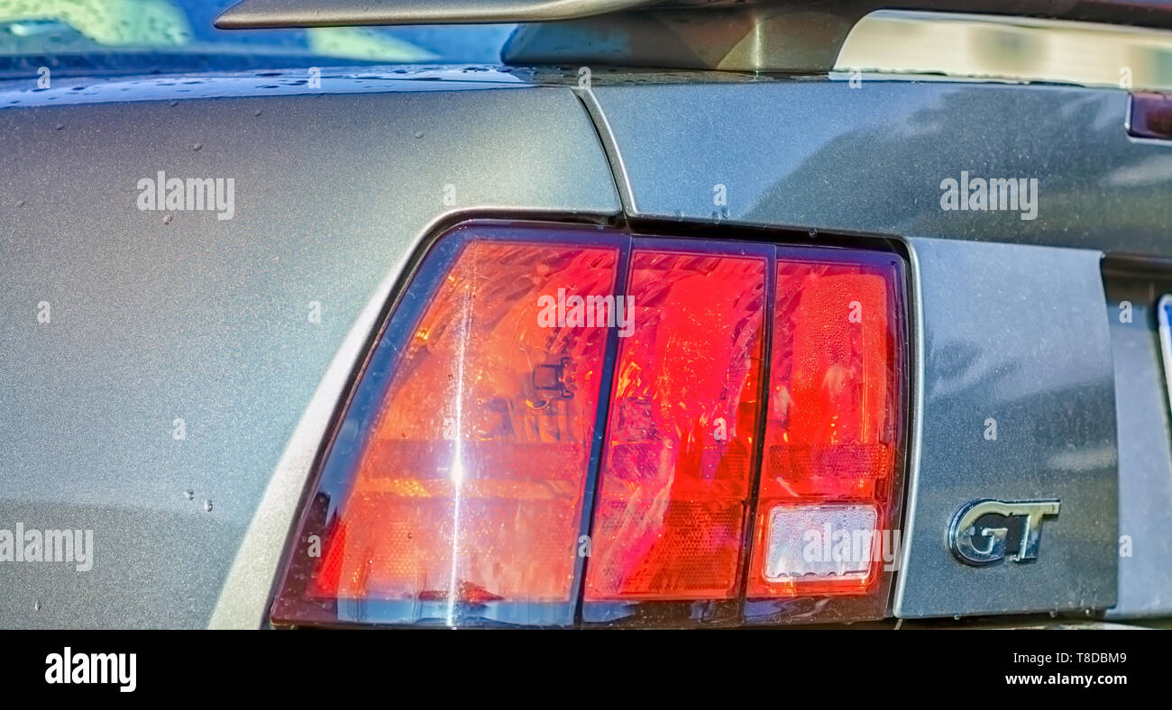 L'arrière gauche du profil d'un lavé de pluie Ford Mustang GT Coupé. Becquet arrière, feux arrière, et le logo GT sont visibles. Banque D'Images