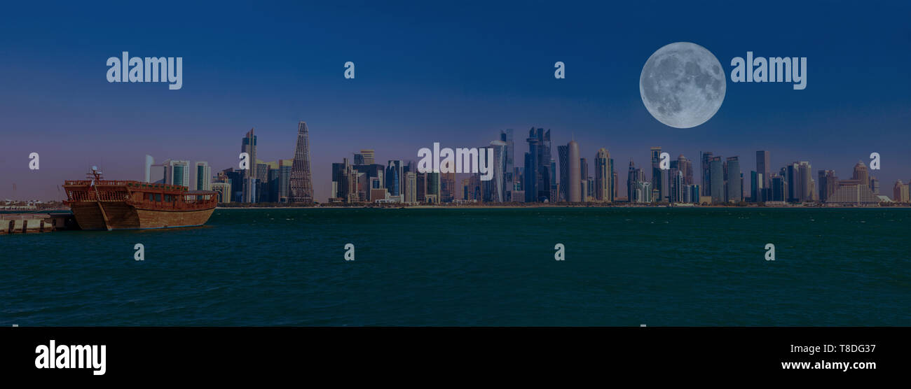 Banner panorama de boutre traditionnel en bois et des tours de l'Ouest Bay skyline avec pleine lune au soir dans la baie de Doha. Capitale du Qatar, au Moyen-Orient Banque D'Images