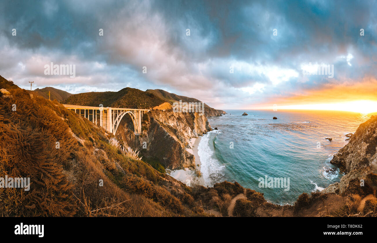 Superbe vue panoramique sur le pont du ruisseau Bixby historique le long de la route 1 de renommée mondiale dans la belle lumière du soir au coucher du soleil d'or, Big Sur, California, US Banque D'Images