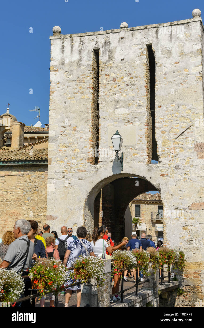 SIRMIONE, Lac de Garde, ITALIE - Septembre 2018 : Les personnes qui traversent un pont pour entrer dans la vieille ville et Château Scaliger. C'est une forteresse médiévale dans l'lak Banque D'Images