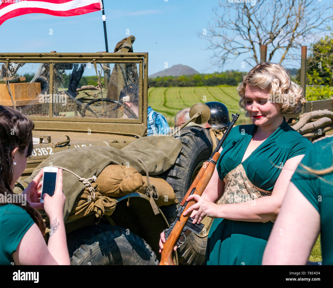 East Lothian, Royaume-Uni.12 mai 2019.Expérience en temps de guerre : un événement avec toutes les choses liées aux guerres mondiales.Les véhicules de l'armée américaine de la deuxième guerre mondiale sont exposés.Chanteurs le groupe de chanteurs Ragtime Dolls prend des photos avec un fusil Banque D'Images