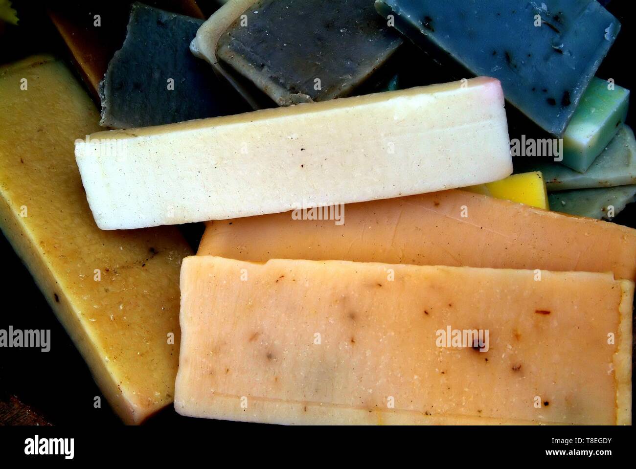 Morceaux de savon quadrangulaire de diverses couleurs affichées sur du papier journal, regroupées par Couleurs : brun-blanc-rouge-orange-jaune-vert. Banque D'Images