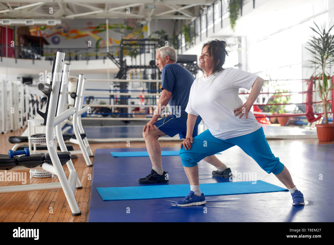 Couple actif des aînés de l'exercice à la salle de sport. Sportive heureux femme âgée l'exécution de l'exercice dans un club de remise en forme. Comment rester active à tout âge. Banque D'Images