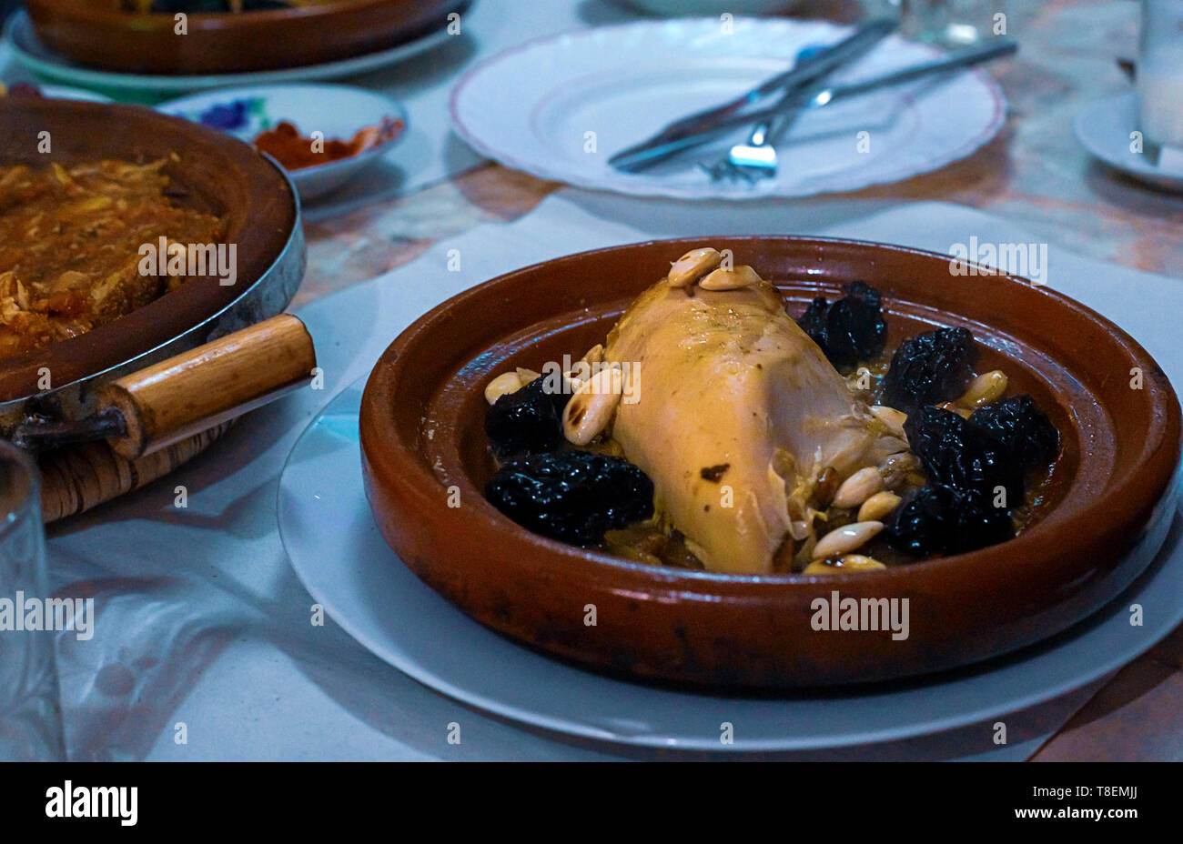 Poulet mijoté avec les pruneaux, les amandes, les oignons et saupoudré de sésame, tajine marocain, Banque D'Images