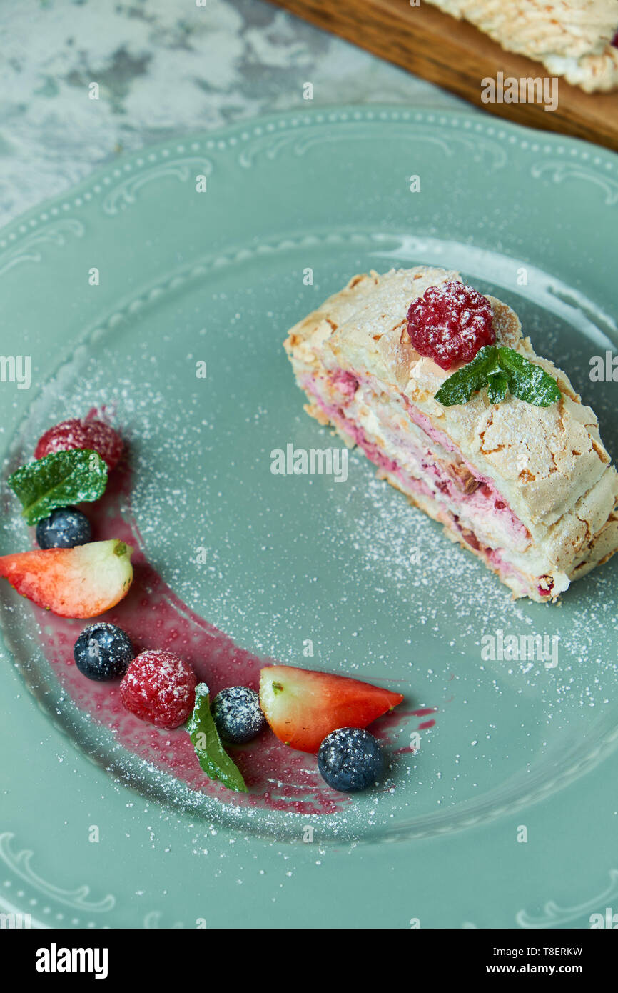 Gateau Roule A La Meringue Tranche Sur Une Assiette De Fruits Rouges Photo Stock Alamy