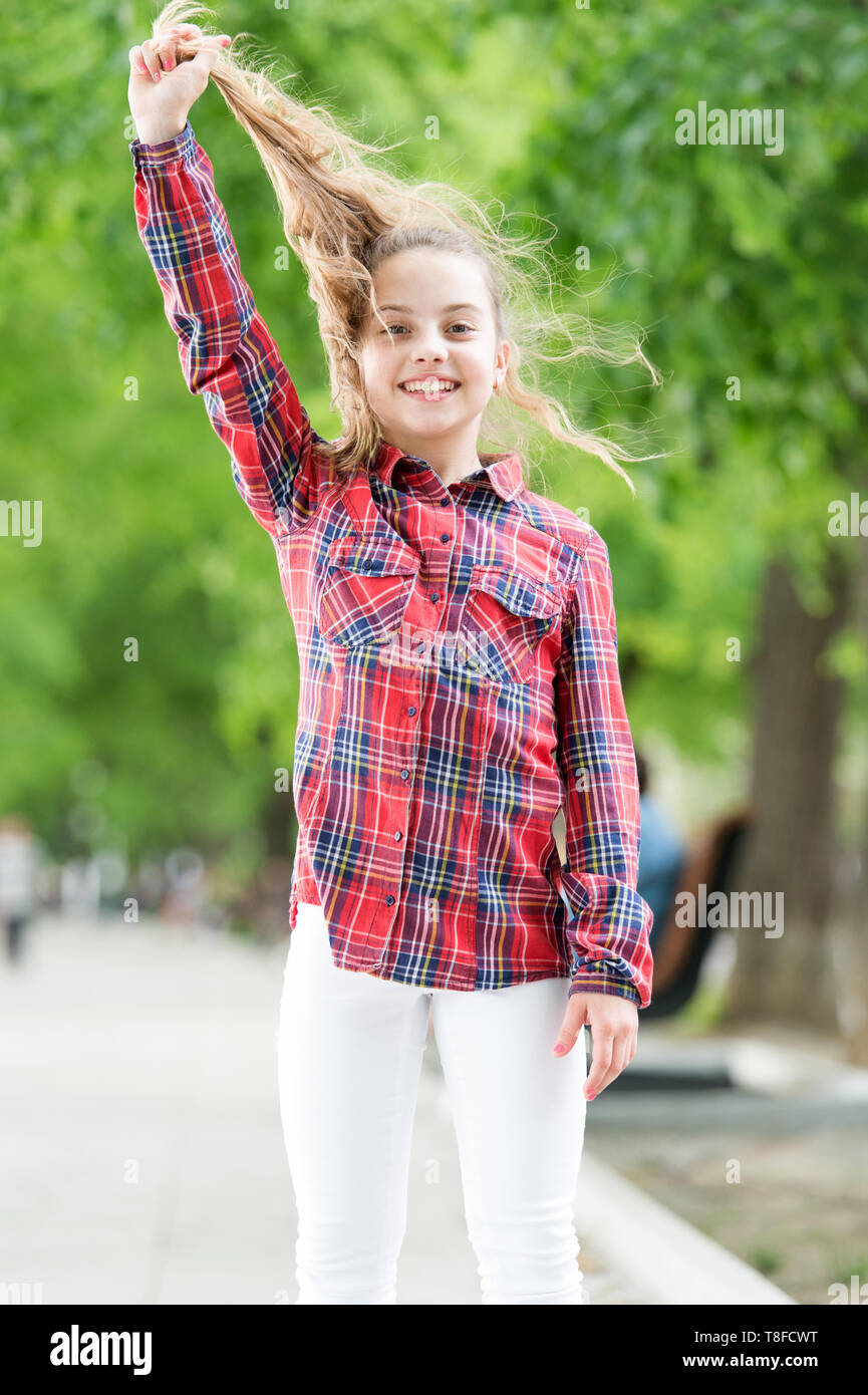 Sentiment intime et confortable sur jour de vent. Traiter les cheveux longs sur jour de vent. Coiffures à porter les jours de vent. Coiffures coupe-vent. Peu de fille cute child profitez à pied sur la nature de fond jour venteux. Banque D'Images