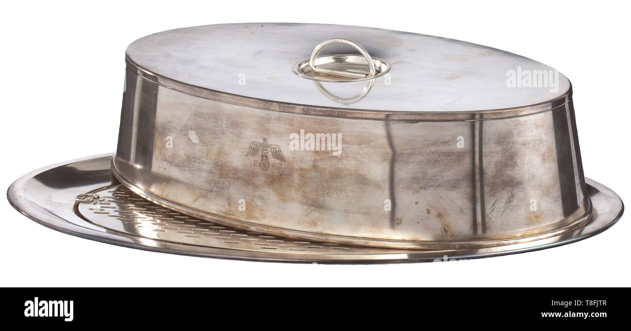 Adolf Hitler - un grand plat de service avec de rares vidange insérer et de la cloche de l'argenterie de la Neue Reichskanzlei, Berlin plaqué argent dur. La plaque ovale porte l'aigle aux ailes repliées nationale sur 'RK' sur une frontière, la marque d'origine 'Wellner' - '120' et le numéro '1565' 63 sont sur le fond, dimensions 64 x 42,5 cm. Les très rares vidange insérer porte l'aigle national avec 'RK' et 'Maker's Mark Wellner' - '36'. Sur la cloche correspondant national d'Hitler avec l'aigle, plus répandu des ailes, bien connu de son argenterie, mais également au-dessus de , Editorial-Use-seulement Banque D'Images