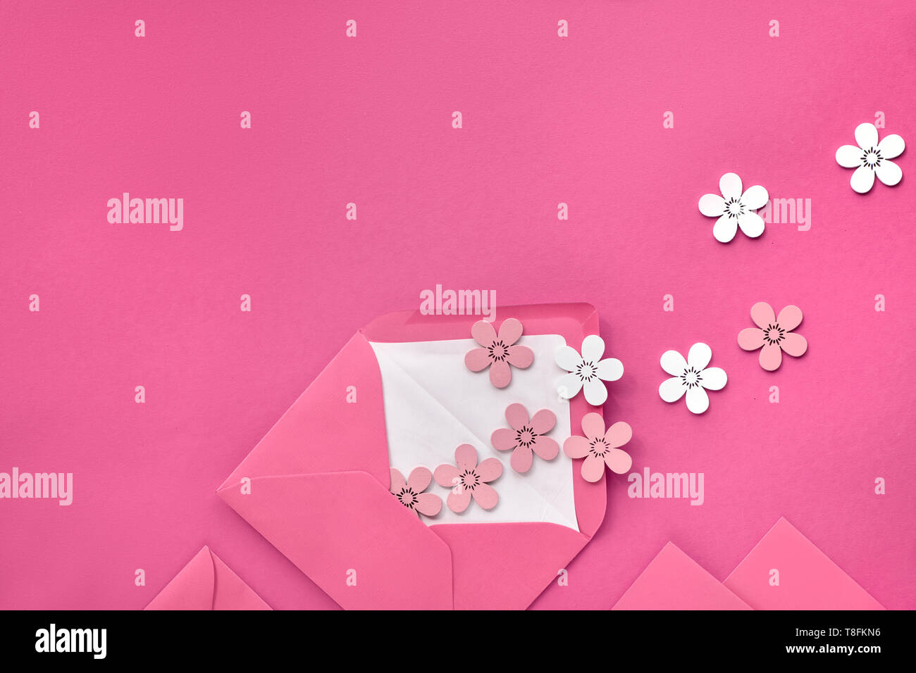 Télévision printemps pondent sur du papier rose avec des fleurs de couleur pêche et wihte volant d'enveloppe ouverte. Fond de papier minimalisti millénaire Banque D'Images