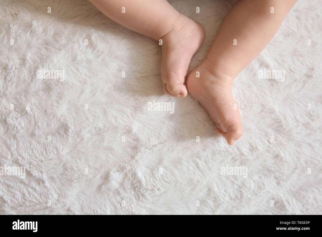 Les jambes d'adorables petits baby lying on bed Banque D'Images