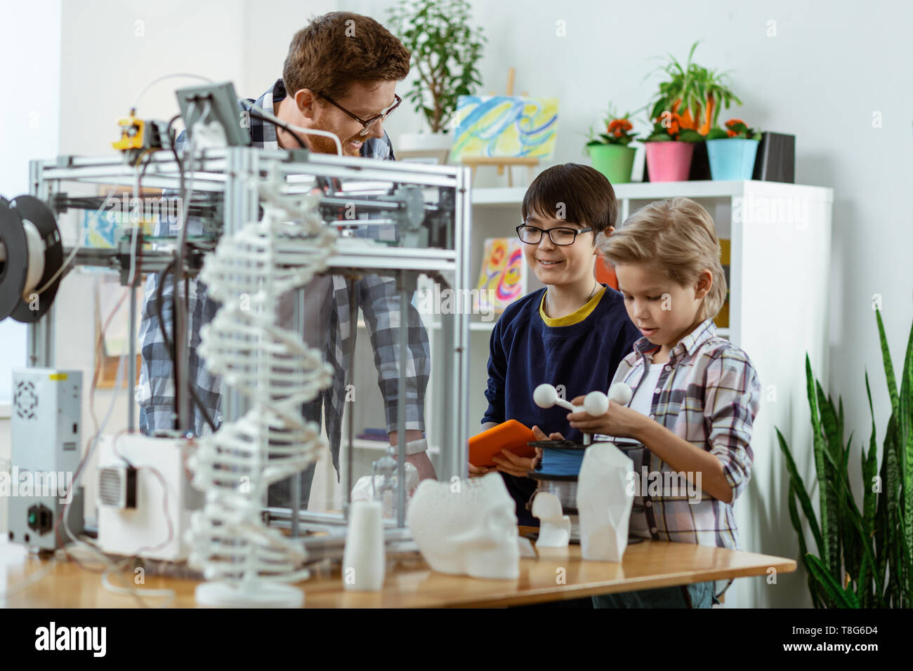 Les enfants intéressés l'inspection 3D-printer placé sur la table de travail Banque D'Images