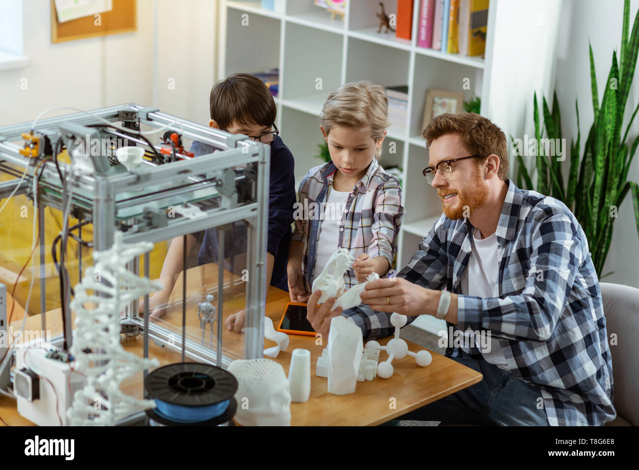 Smiling ginger tuteur ayant leçon pratique avec les étudiants intéressés Banque D'Images