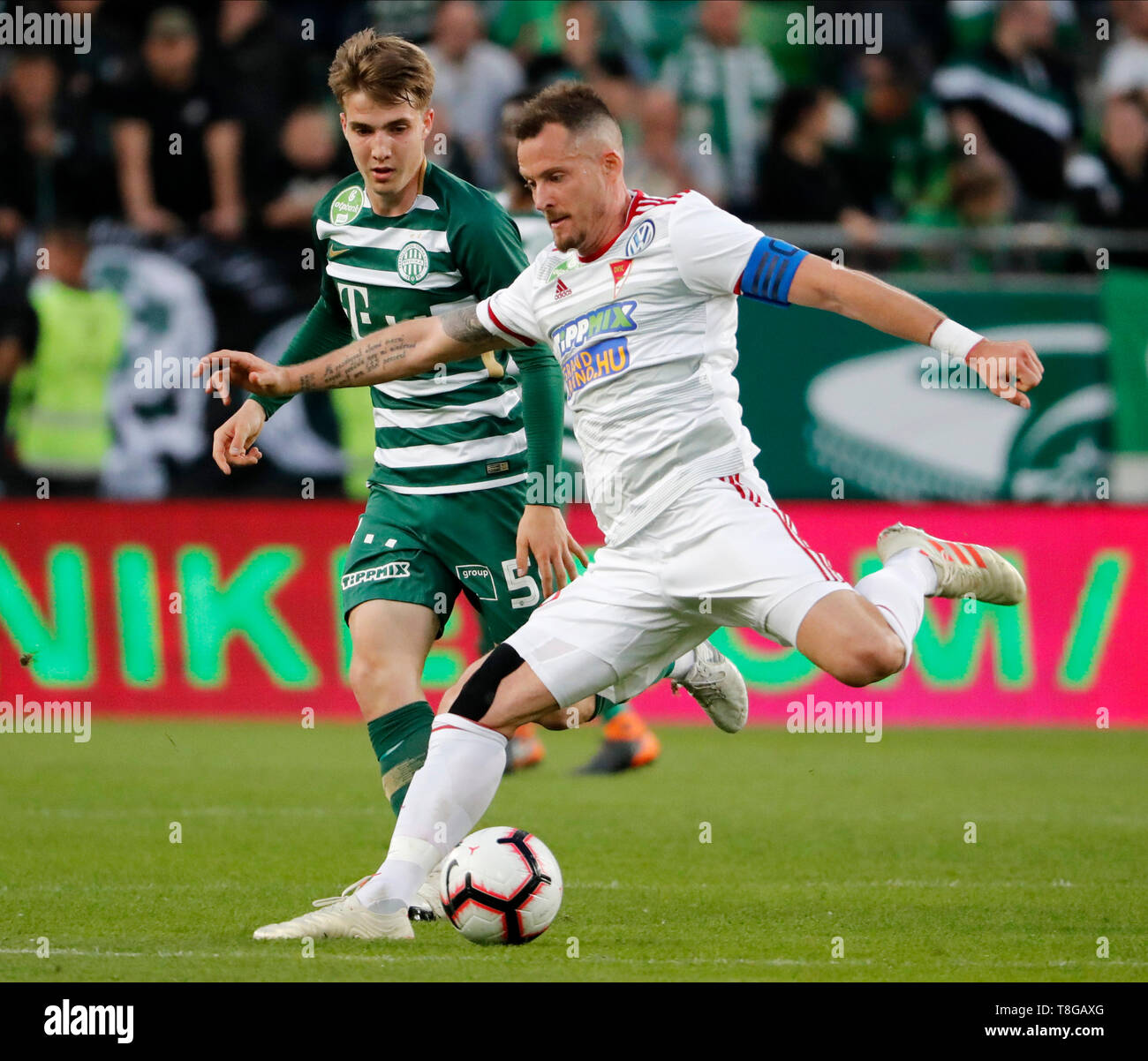 BUDAPEST, HONGRIE - 11 MAI : (r-l) Daniel Tozser de DVSC frappe la balle avant qu'Andras Csonka Ferencvarosi TC au cours de la Banque Hongroise OTP Liga match entre Ferencvarosi TC et DVSC de Groupama Arena le 11 mai 2019 à Budapest, Hongrie. Banque D'Images