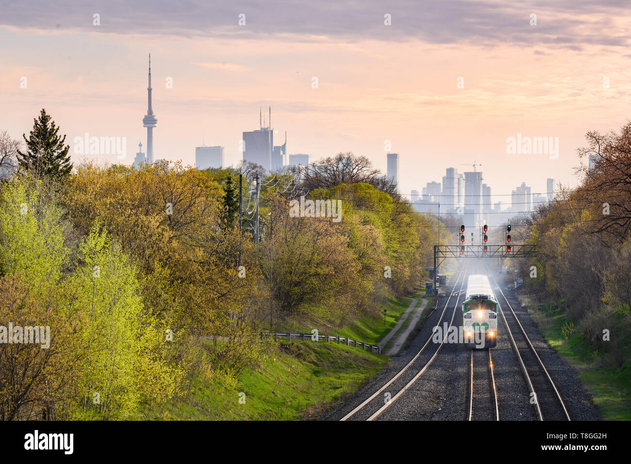 Un train s'approche en direction de l'aller à Toronto Danforth's East End près de coucher du soleil. Banque D'Images