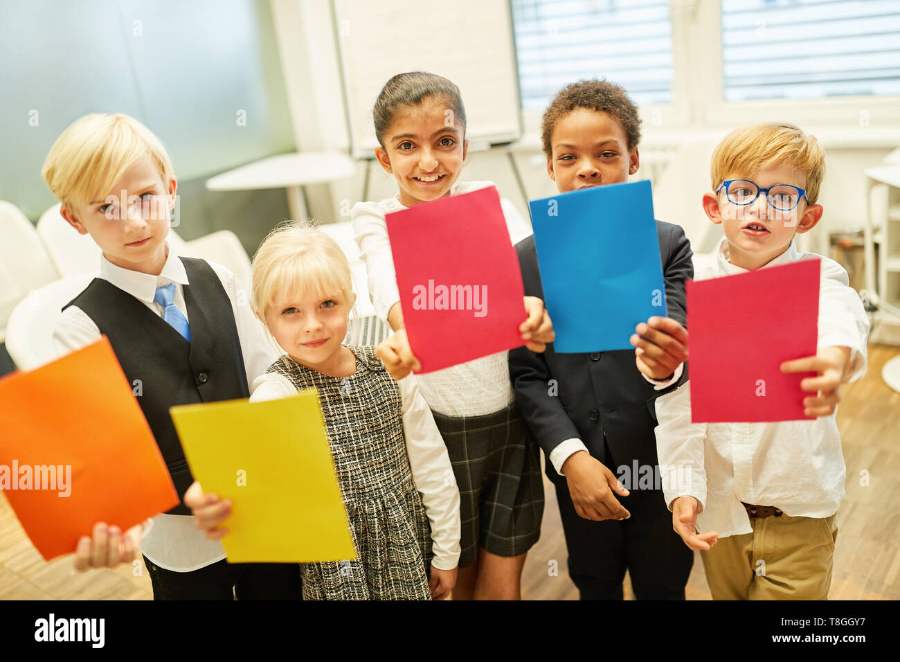 Les enfants comme les gens d'affaires avec feuillets colorés faire un jeu d'équipe Banque D'Images