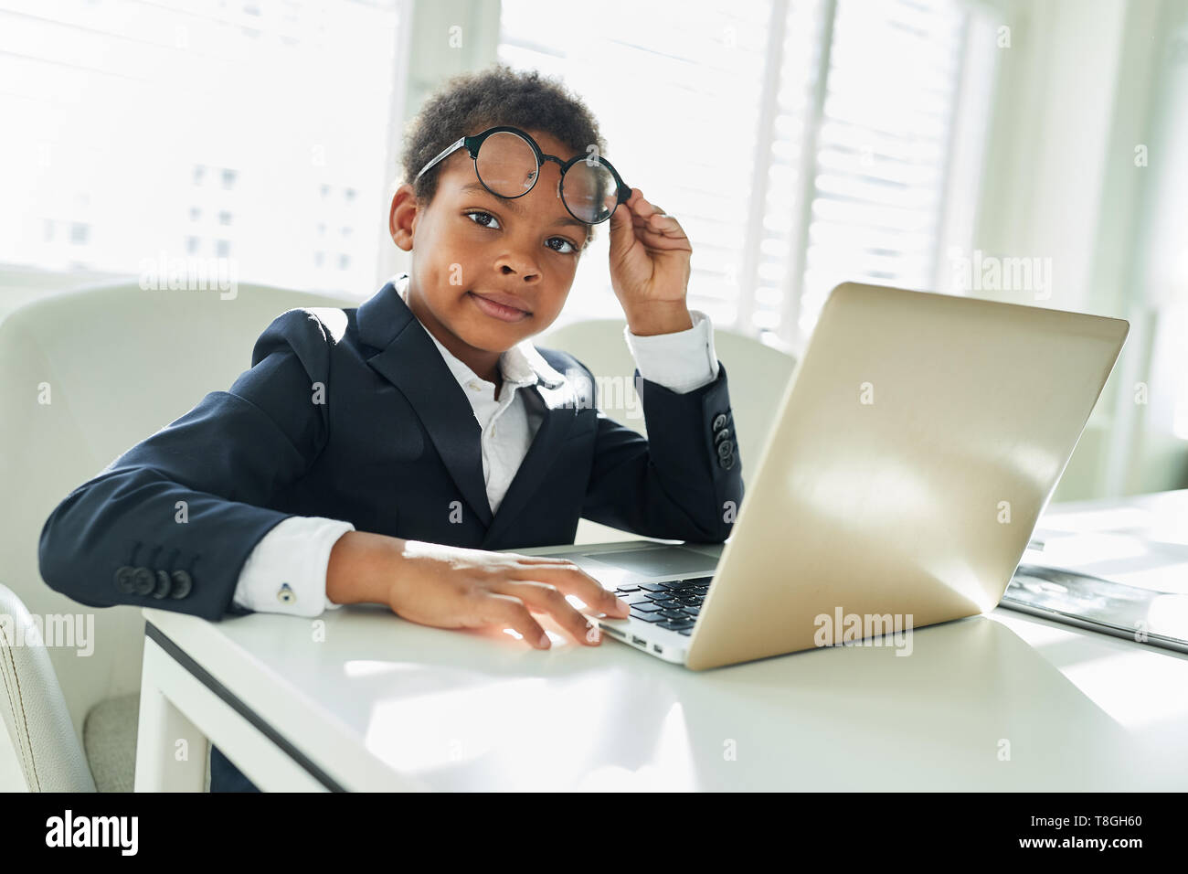 African boy en tant que gestionnaire ou d'un avocat avec des lunettes on laptop computer Banque D'Images