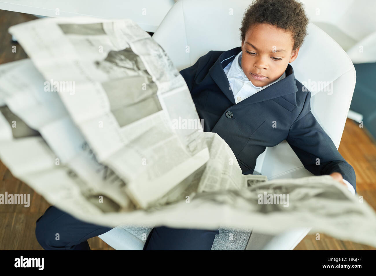 African boy comme un homme d'affaires ou avocat lit un journal quotidien Banque D'Images