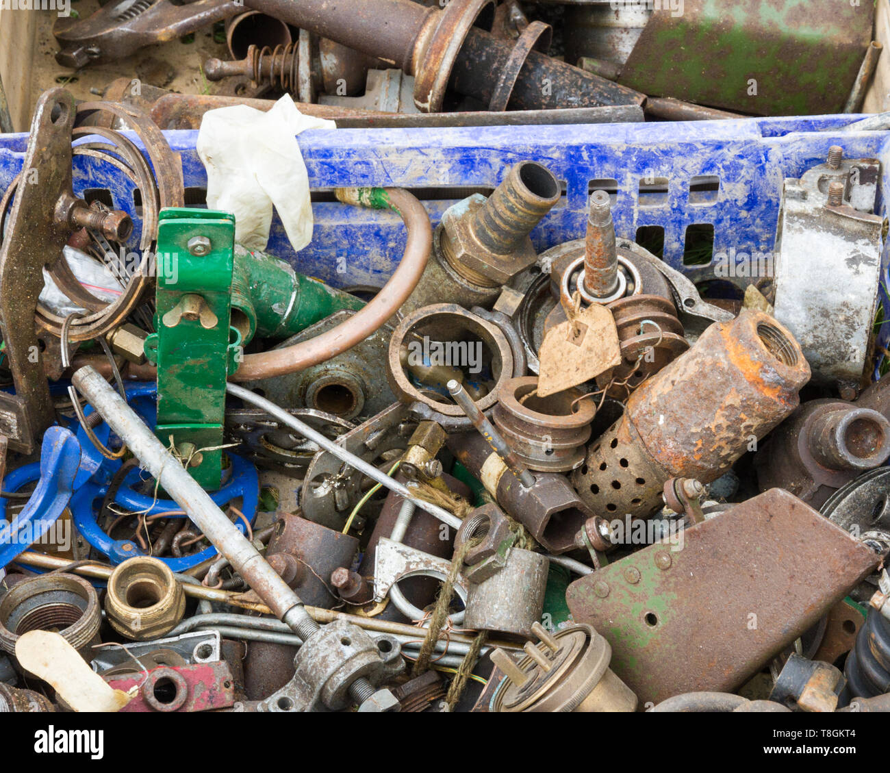 Un gros plan d'un assortiment et brouillées ensemble d'outils, Moteur et pièces de machine dans une caisse en plastique bleu sale. En vente à un pays. Banque D'Images