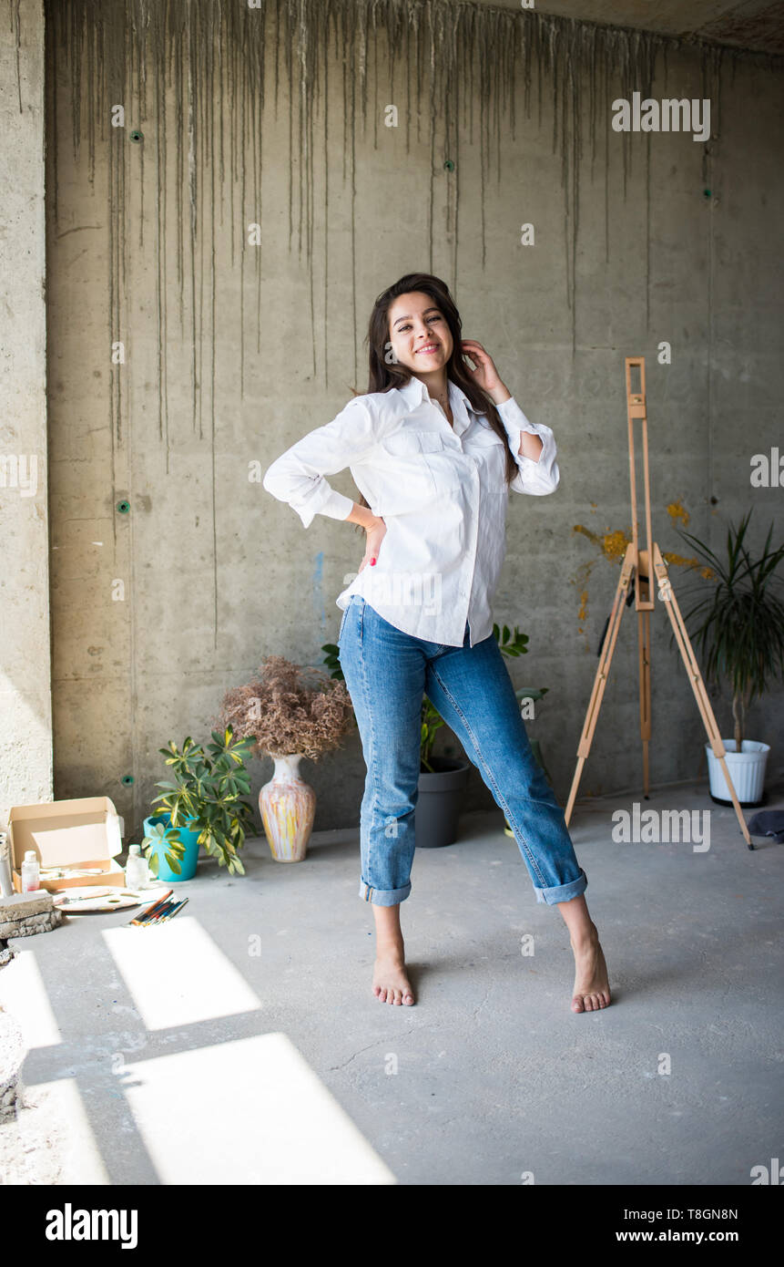 Belle jeune femme artiste en chemise blanche danser pieds nus dans son loft  studio artistique bohème Photo Stock - Alamy