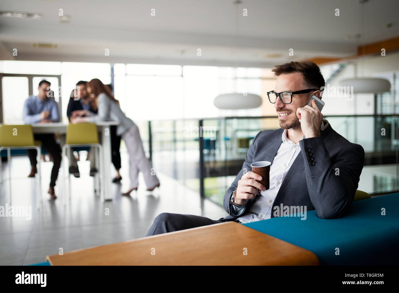 L'homme d'affaires dans une entreprise de même et une tasse de café dans un bureau Banque D'Images