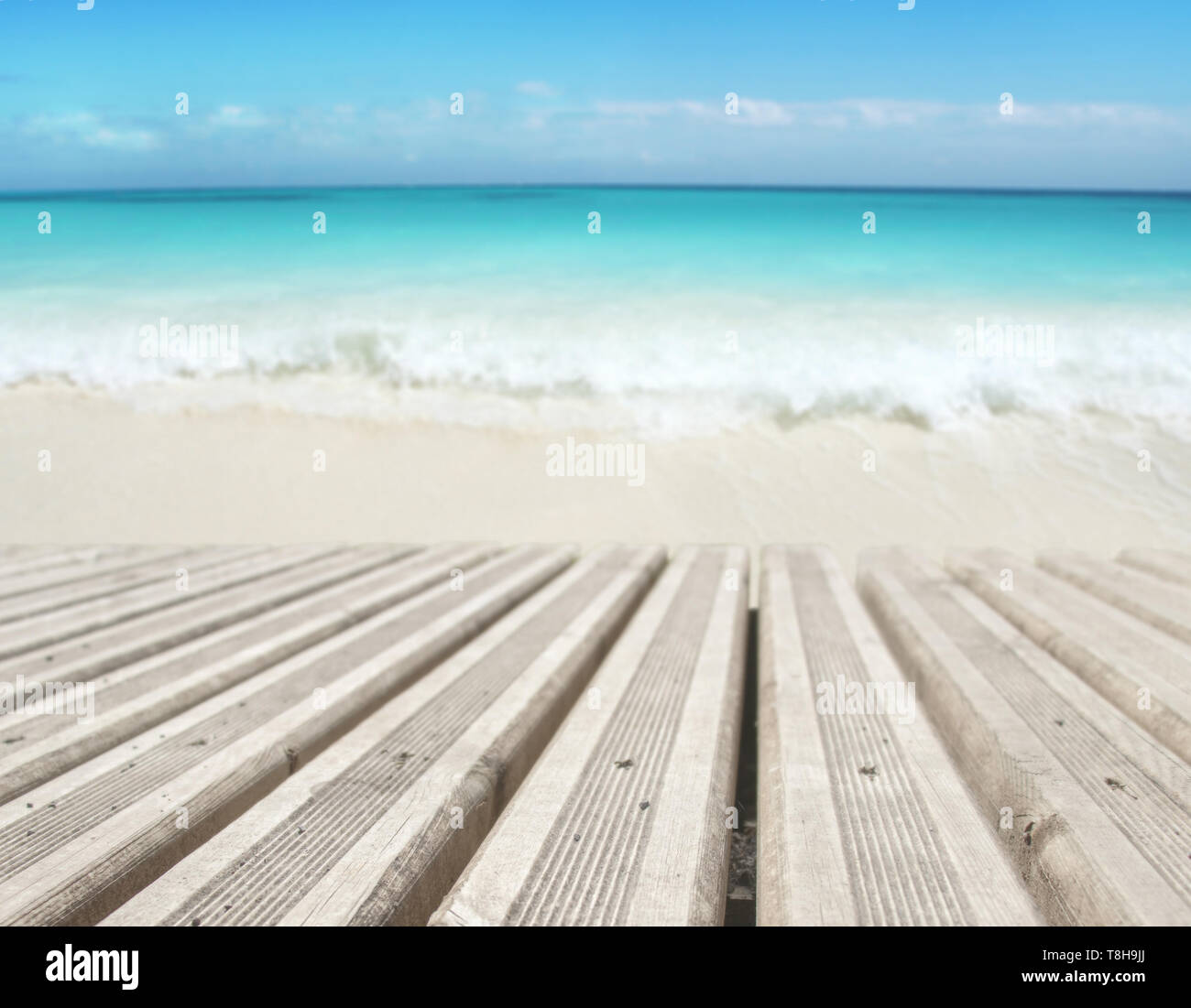 Planches en bois sur la plage arrière-plan flou. Île tropicale paradisiaque. Sandy shore lave par l'onde. L'eau de l'océan turquoise brillant. Dream Banque D'Images