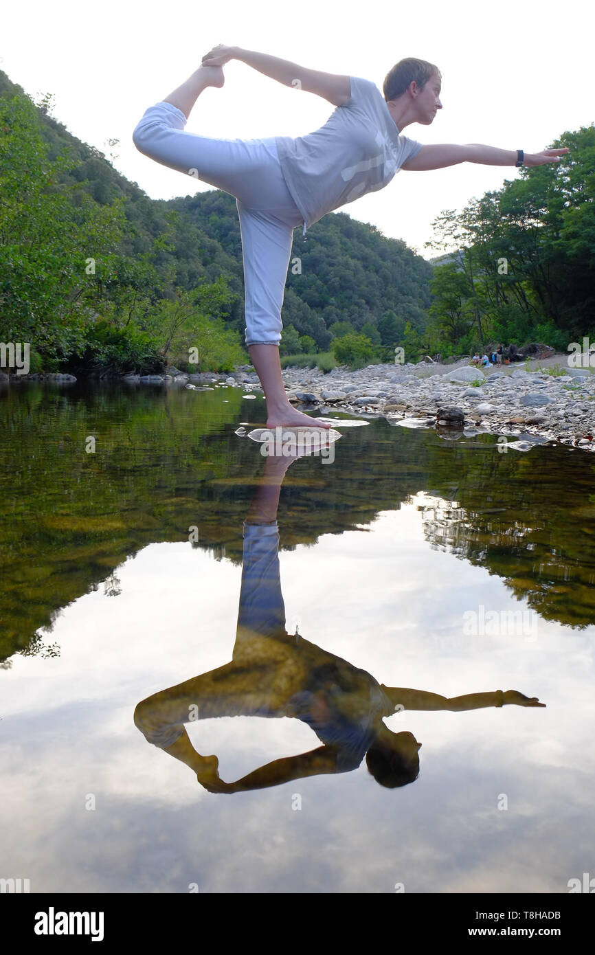 Yoga sur un rocher dans une rivière de montagne Banque D'Images