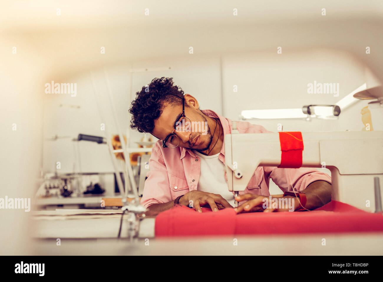 Jeune homme d'une robe de couture dans un studio. Banque D'Images