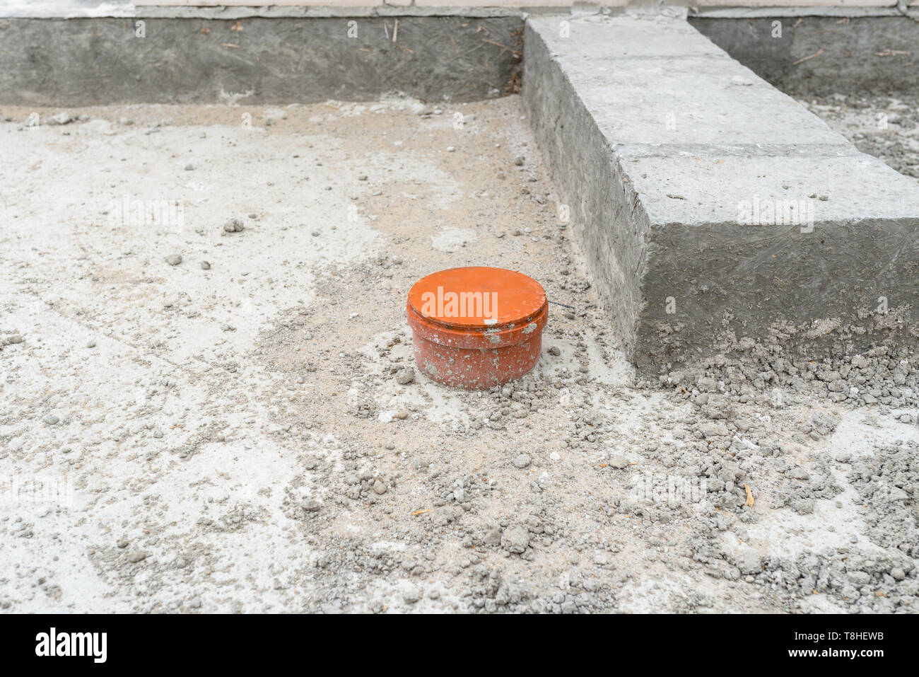 Couverts d'égout qui dépassent de la fondations de la maison en construction. Banque D'Images