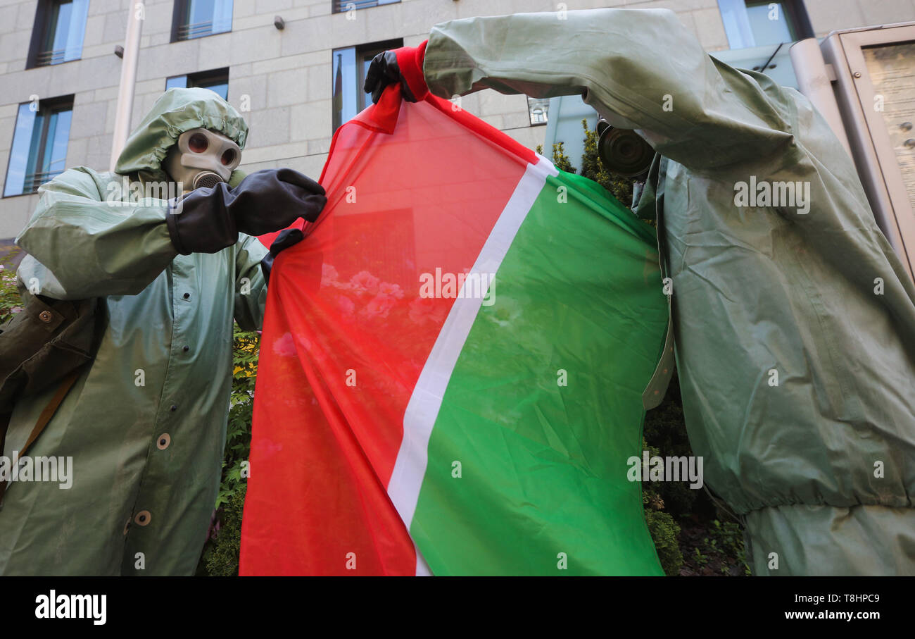 13 mai 2019 - Kiev, Ukraine - des militants d'émigrants de l'Association des peuples autochtones de Russie portant des combinaisons hazmat tenir Tatarstan drapeau comme ils les piquets de l'ambassade allemande à la demande de vérifier les compagnies pétrolières russes qui avaient exporté du pétrole brut vers les pays de l'UE et, d'activistes pensent, il a conduit à une catastrophe environnementale dans le Tatarstan, à Kiev, Ukraine, le 13 mai 2019. La Commission d'enquête, six suspects identifiés dans la contamination de millions de barils de pétrole brut, ce qui éteint les expéditions de pipeline à certains pays européens. En mars et avril de cette année, certains des su Banque D'Images