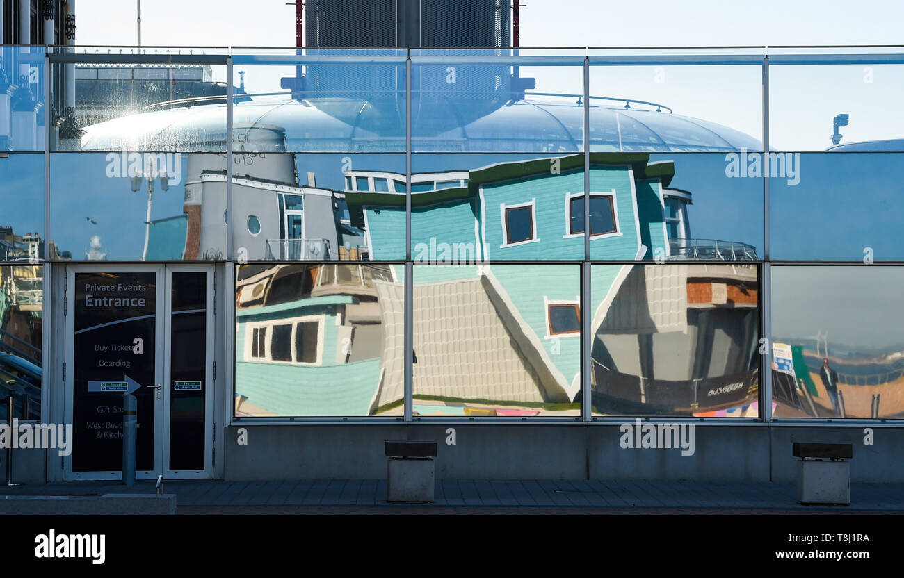 Brighton, UK. 14 mai, 2019. La nouvelle attraction touristique de Brighton à l'envers la Chambre se reflète dans les fenêtres de la British Airways à proximité i360 tour d'observation sur le front de mer près de la jetée ouest sur une belle matinée ensoleillée avec des températures qui atteignent dans les années 20 dans certaines parties de la Grande-Bretagne aujourd'hui. La maison est à l'envers en raison d'ouvrir au public le week-end prochain . Crédit : Simon Dack/Alamy Live News Banque D'Images