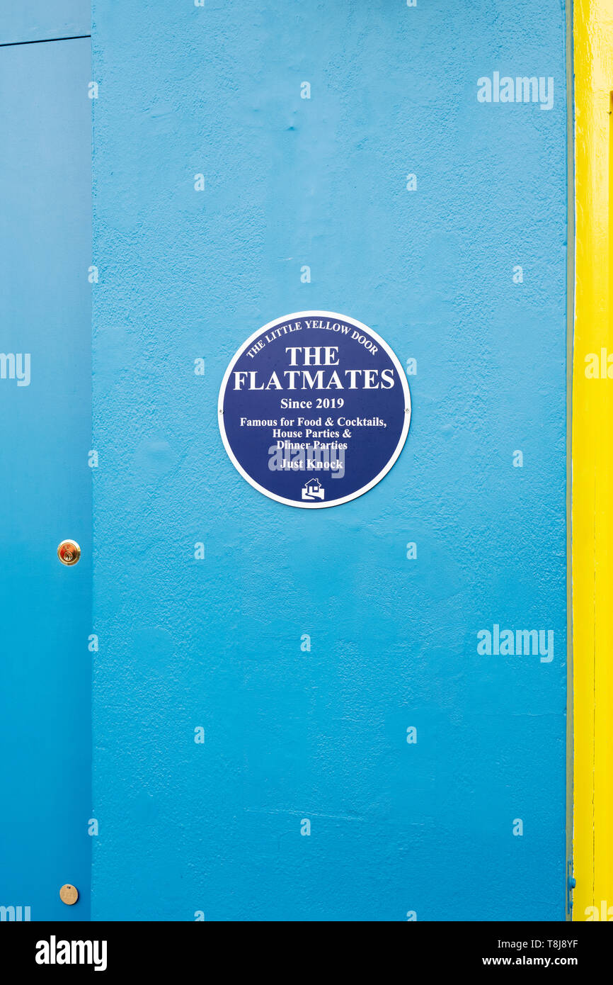 La petite porte jaune blue plaque signe sur un mur bleu. Tous les Saints Road, Notting Hill, Londres, Angleterre Banque D'Images