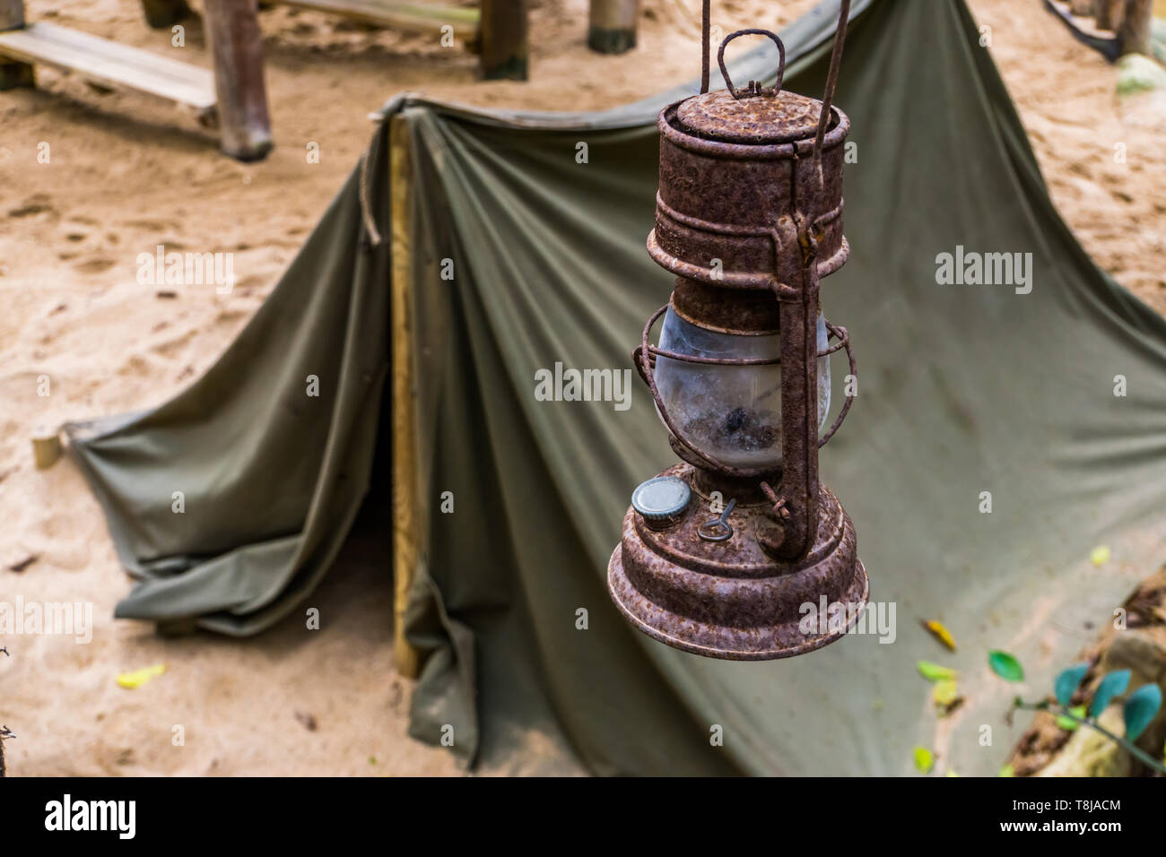 Old rusty lanterne avec une tente dans l'arrière-plan, le camp de mineurs, la survie de la randonnée dans la nature Banque D'Images