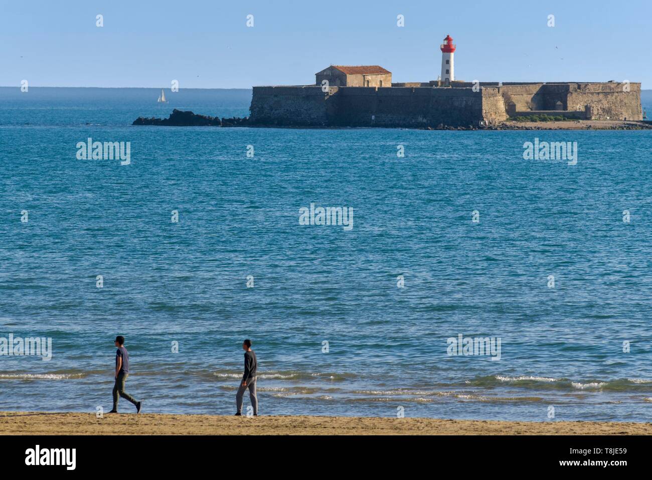 La France, l'Hérault, Agde, Le Cap d'Agde, la plage de Richelieu, les marcheurs avec le Fort de Brescou en arrière-plan Banque D'Images